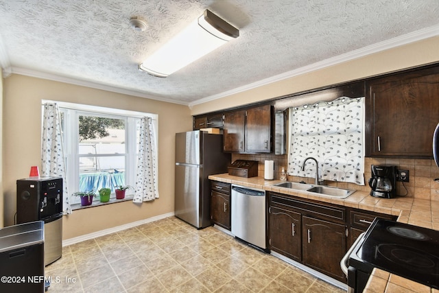 kitchen featuring tasteful backsplash, dark brown cabinetry, stainless steel appliances, sink, and tile counters