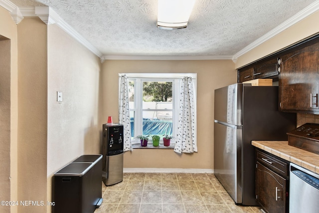 kitchen featuring tile counters, dark brown cabinetry, ornamental molding, and appliances with stainless steel finishes