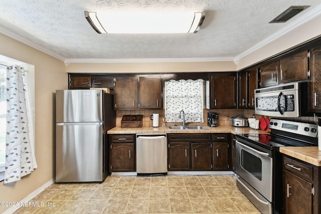 kitchen featuring appliances with stainless steel finishes, backsplash, dark brown cabinets, and sink