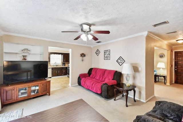 carpeted living room featuring ceiling fan, a textured ceiling, and ornamental molding