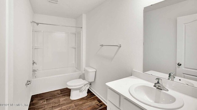 full bathroom featuring vanity, washtub / shower combination, hardwood / wood-style flooring, and toilet