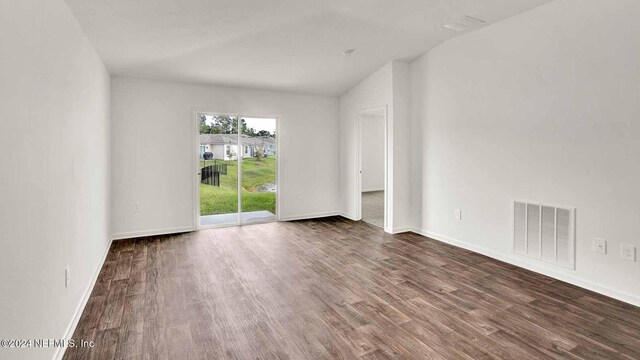 spare room with lofted ceiling and dark hardwood / wood-style flooring