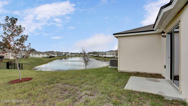 view of yard with a water view and central AC unit