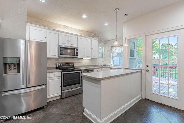 kitchen featuring decorative light fixtures, tasteful backsplash, white cabinetry, appliances with stainless steel finishes, and lofted ceiling