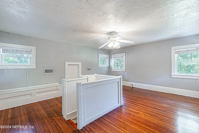 interior space with dark wood-type flooring, ceiling fan, and a textured ceiling