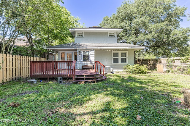 rear view of property with a lawn and a wooden deck