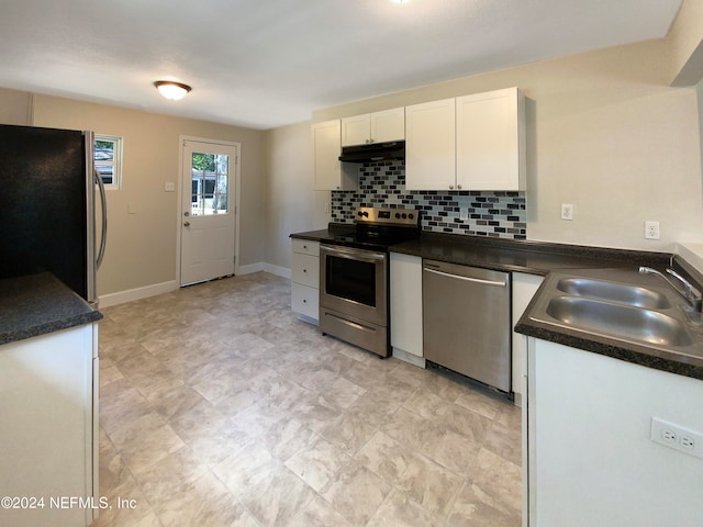 kitchen featuring sink, light tile floors, appliances with stainless steel finishes, backsplash, and white cabinetry