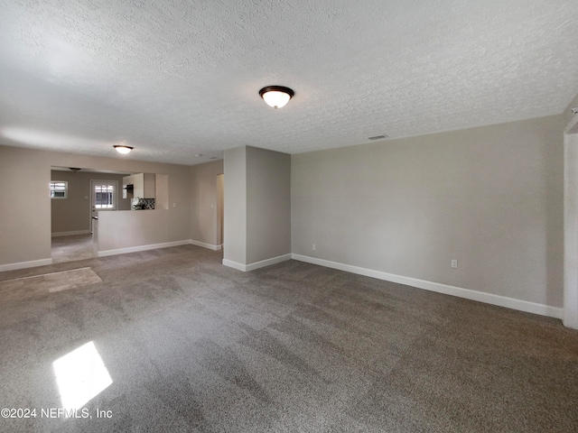 carpeted spare room featuring a textured ceiling