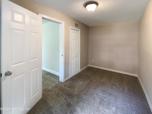 unfurnished bedroom featuring dark carpet