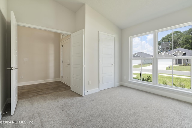 unfurnished bedroom featuring carpet and vaulted ceiling