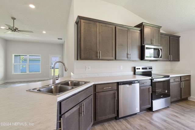 kitchen featuring dark brown cabinetry, ceiling fan, sink, stainless steel appliances, and vaulted ceiling