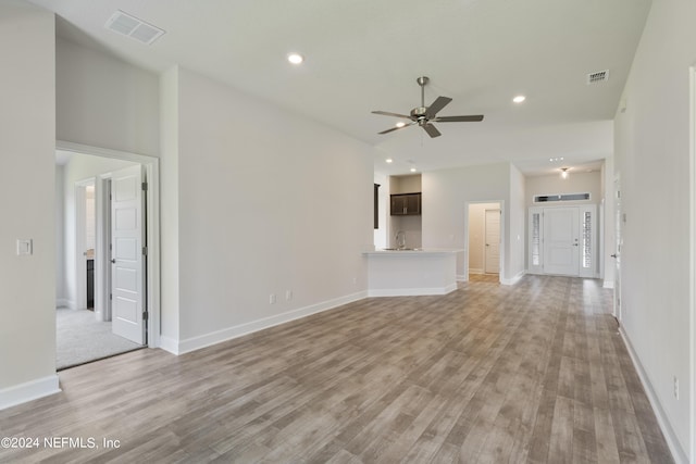 unfurnished living room with ceiling fan and light wood-type flooring