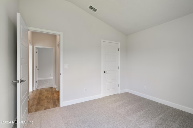 unfurnished bedroom featuring carpet floors and vaulted ceiling