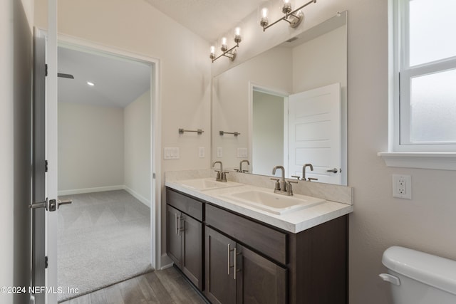 bathroom with hardwood / wood-style floors, vanity, and toilet