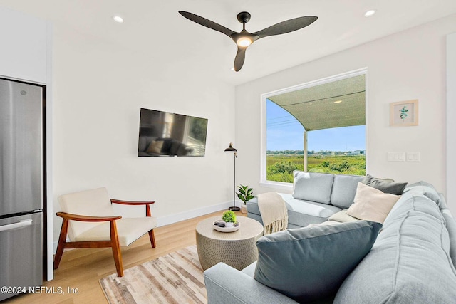 living room featuring ceiling fan and light hardwood / wood-style flooring