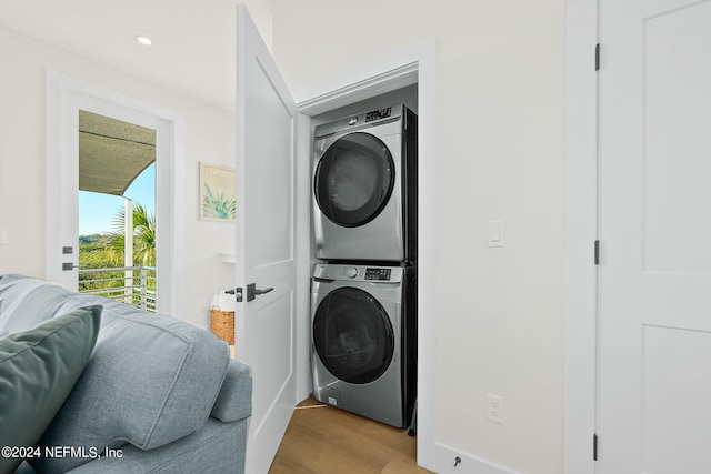 clothes washing area with stacked washer and dryer and light hardwood / wood-style floors