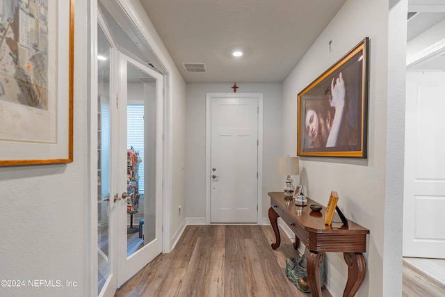 entryway with french doors and light hardwood / wood-style flooring