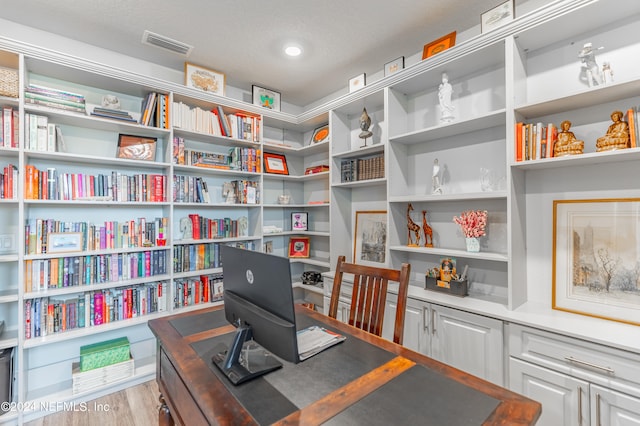 office space featuring light wood-type flooring and a textured ceiling