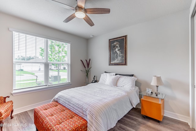 bedroom featuring multiple windows, ceiling fan, and dark hardwood / wood-style flooring