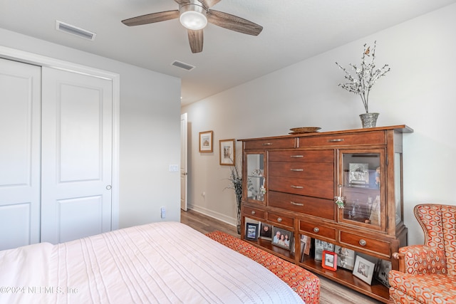 bedroom with ceiling fan, a closet, and light hardwood / wood-style flooring