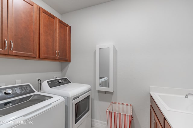 laundry area with washer and dryer, cabinets, and sink