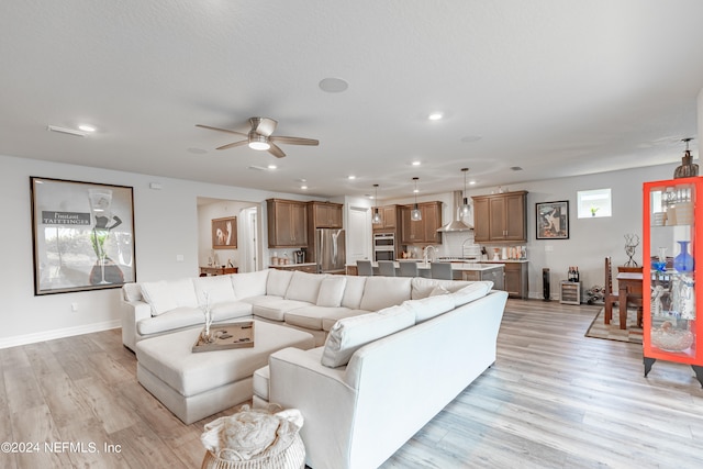 living room with ceiling fan and light wood-type flooring