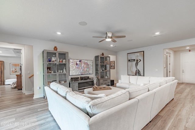 living room with ceiling fan and light hardwood / wood-style flooring