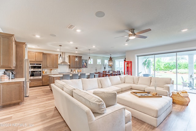 living room with light hardwood / wood-style flooring and ceiling fan