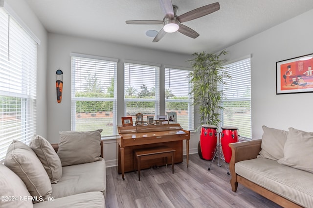 living room with a healthy amount of sunlight, ceiling fan, and light wood-type flooring