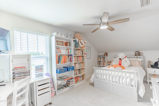 bedroom featuring vaulted ceiling, a textured ceiling, light colored carpet, and ceiling fan