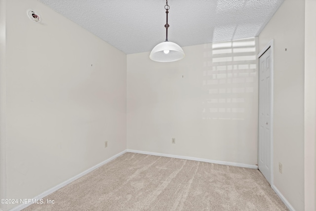 carpeted empty room with a textured ceiling