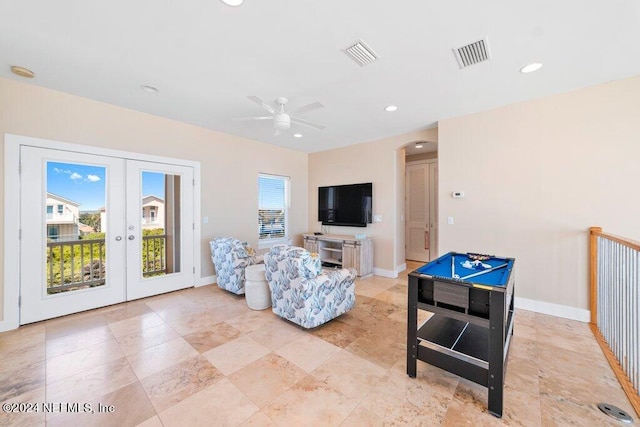 tiled living room featuring french doors and ceiling fan