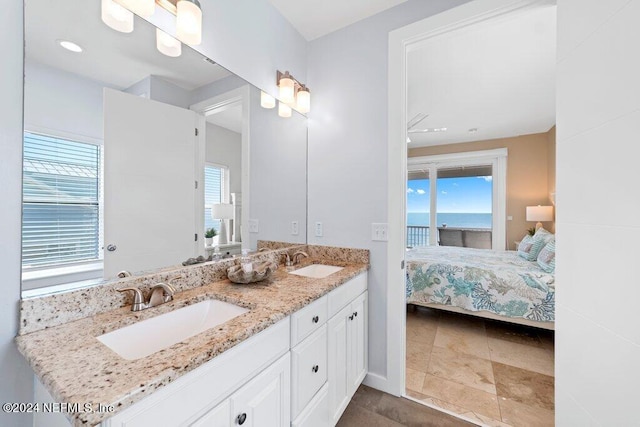 bathroom featuring dual sinks, oversized vanity, a water view, and tile floors