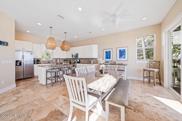 dining room featuring light tile floors, ceiling fan, and sink