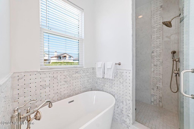 bathroom featuring tile walls and separate shower and tub