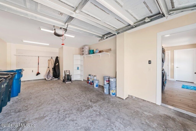 garage with a garage door opener and stacked washer / dryer