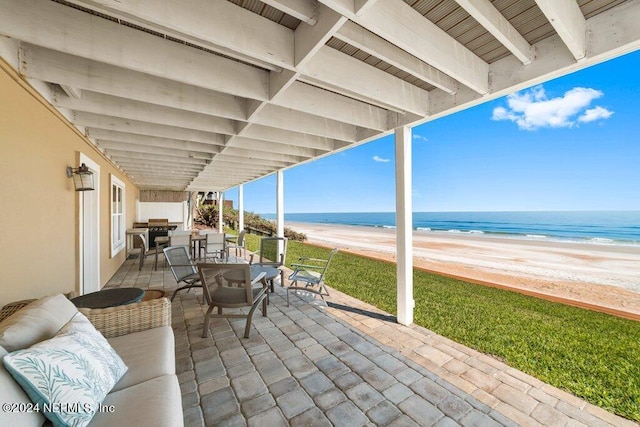 view of patio / terrace featuring a water view and a view of the beach