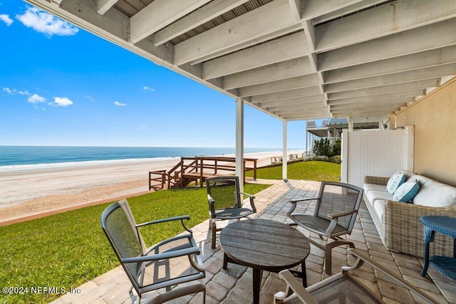 view of patio / terrace with a view of the beach, outdoor lounge area, and a water view