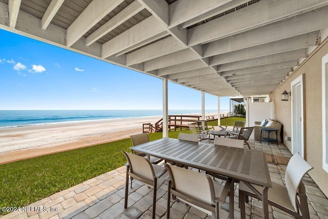 view of terrace featuring a beach view and a water view