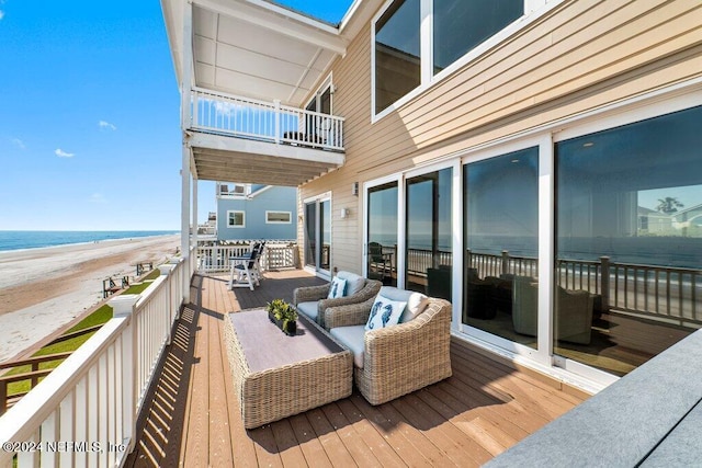 balcony with an outdoor living space and a deck with water view