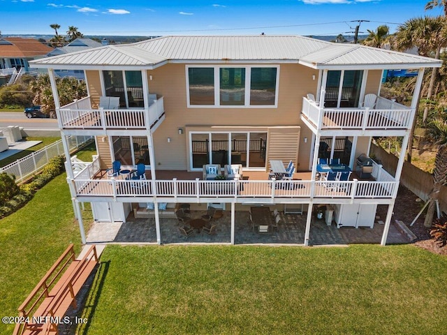 back of property featuring a lawn, a balcony, and a patio