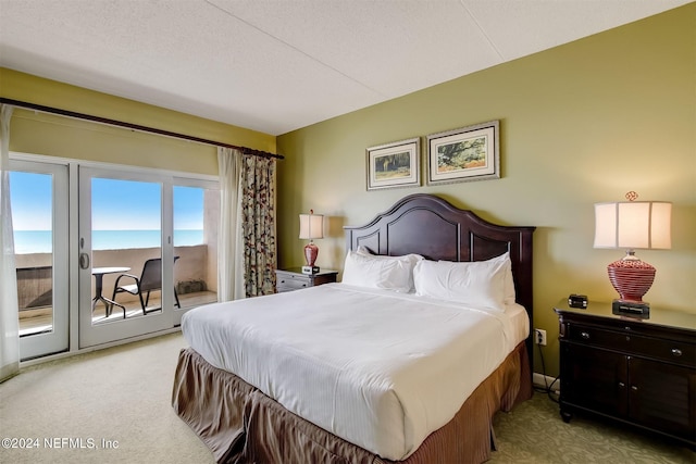 carpeted bedroom with access to outside and a textured ceiling