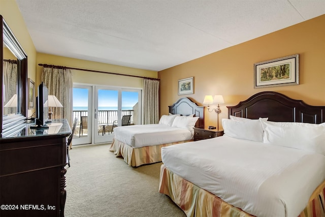 carpeted bedroom featuring a textured ceiling and access to exterior