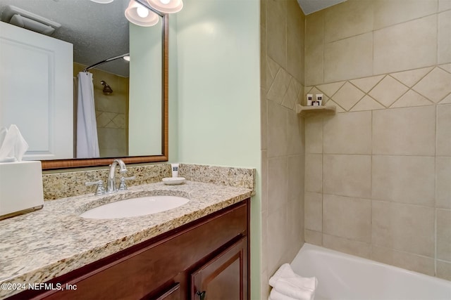 bathroom featuring vanity, a textured ceiling, and shower / tub combo with curtain