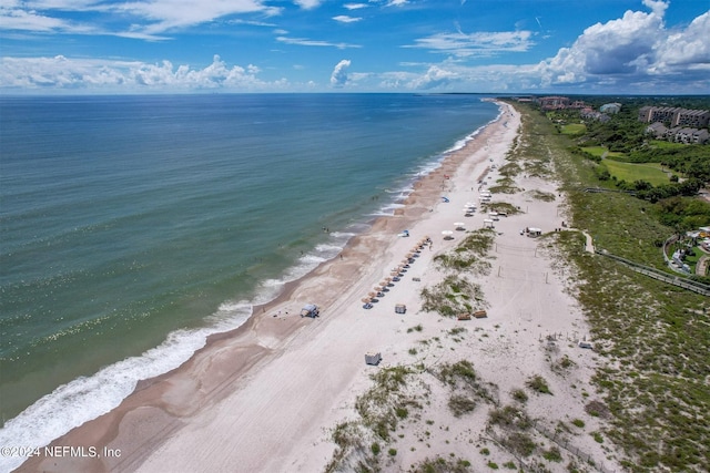 birds eye view of property featuring a water view and a beach view