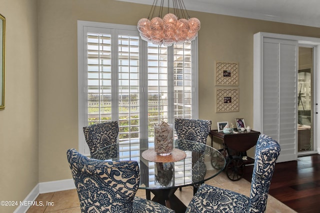 dining area featuring hardwood / wood-style flooring, ornamental molding, and an inviting chandelier