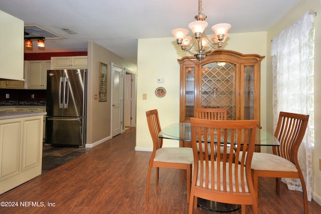 dining area featuring dark wood-type flooring and a chandelier