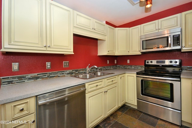 kitchen with cream cabinets, sink, and appliances with stainless steel finishes