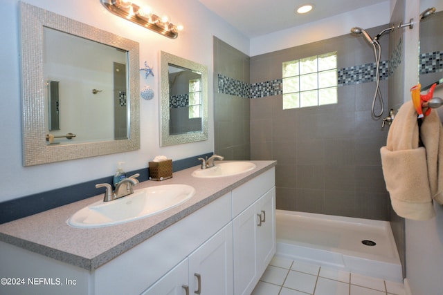 bathroom with oversized vanity, tile floors, tiled shower, and double sink