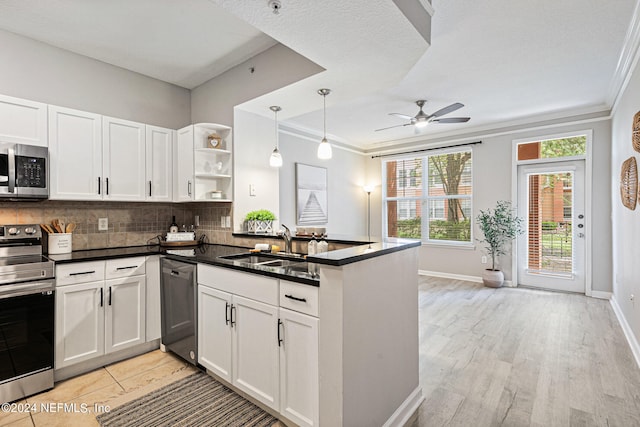 kitchen with ceiling fan, white cabinetry, ornamental molding, and appliances with stainless steel finishes